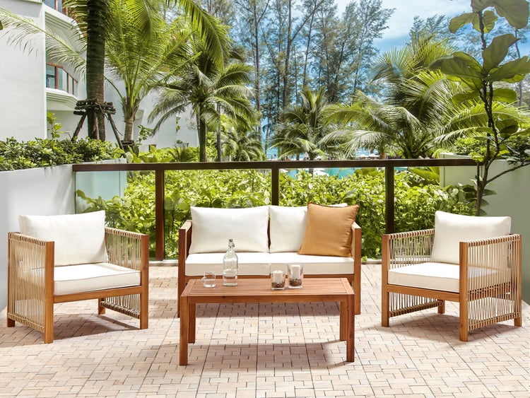 Gartenset mit Sofa, Sessel und Tisch auf einer Terrasse mit tropischer Aussicht