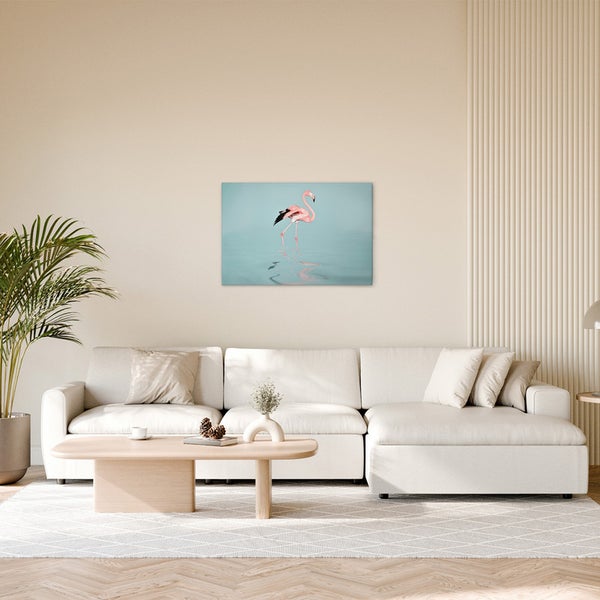 Wohnzimmer mit Sofa, Tisch und einem Bild von einem Flamingo