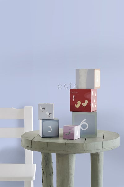 Gestapelte Spielwürfel mit Zahlen und Tiermotiven auf einem runden Tisch