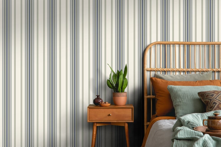 Schlafzimmer mit gestreifter Tapete, Nachttisch und Rattankopfteil