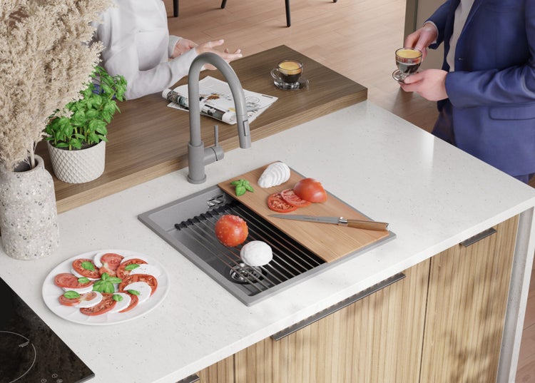 Küchenszene mit Spüle, Armatur, Schneidebrett und Zutaten für Caprese Salat auf der Arbeitsfläche.