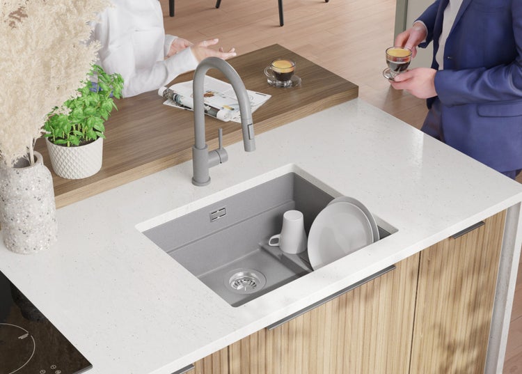 Küchenspüle mit Armatur, Geschirr und zwei Personen