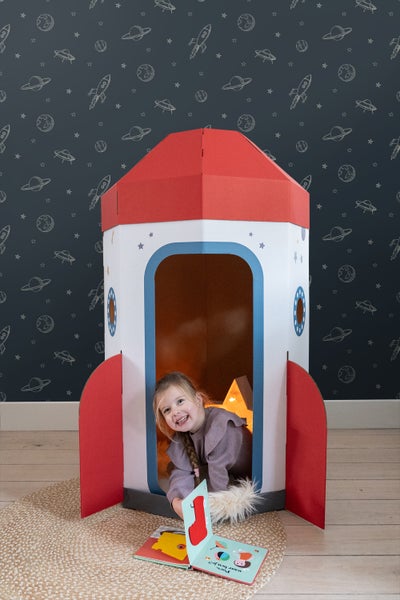Mädchen spielt in einem Raketenspielhaus im Kinderzimmer