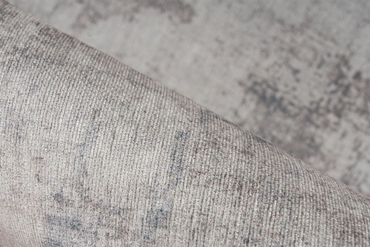 Nahaufnahme eines strukturierten Teppichs mit meliertem Muster in Grau- und Beigetönen.