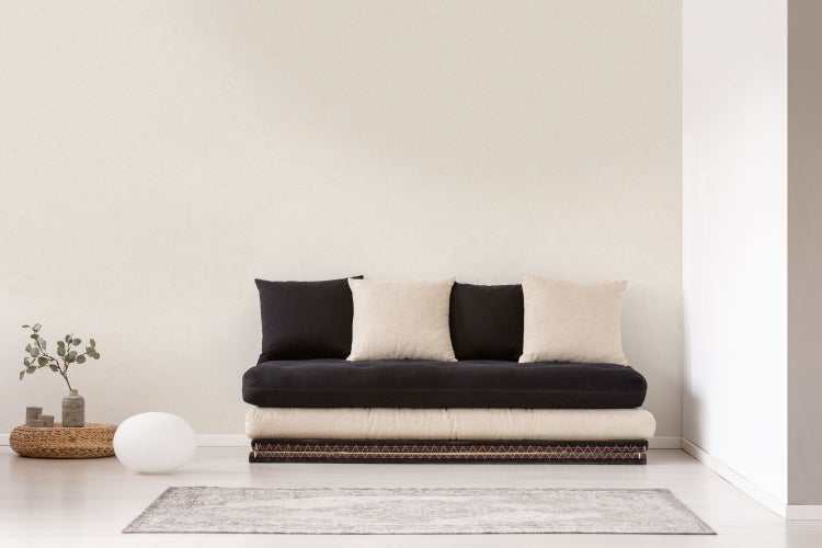 Dekoratives Arrangement mit Spiegel, Vase, Zierblatt und Kommode auf einem Tisch