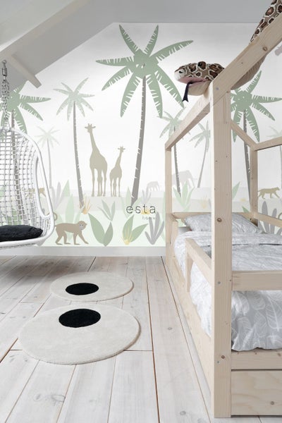 Kinderzimmer mit Holzbett, Hängesessel und Teppichen vor einer Wand mit Dschungelmotiven