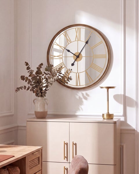 Wandspiegel mit integrierter Uhr im klassischen Design, montiert über einem modernen Sideboard mit Vase und dekorativer Leuchte.