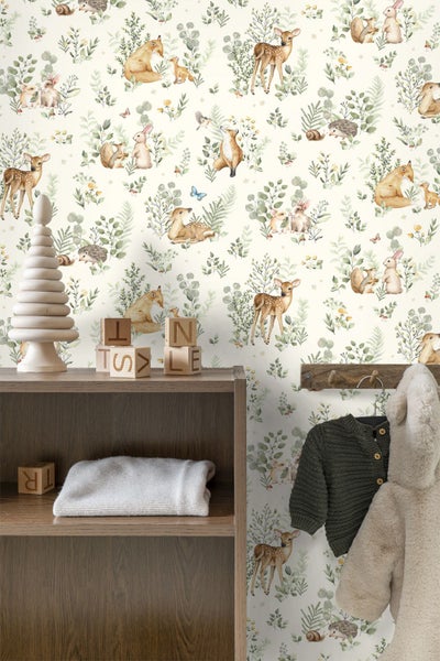 Vliestapete mit Waldtiermotiv im Kinderzimmer, kombiniert mit dunklem Holzregal und Kinderkleidung.