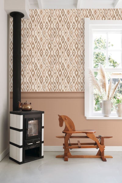 Wohnraum mit Kaminofen, Holzpferd und gemusterter Tapete