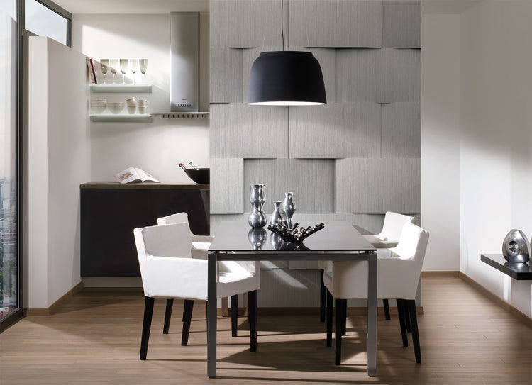 Modernes Esszimmer mit strukturierten 3D-Wandpaneelen, schwarzem Esstisch, weißen Sesseln und einer großen Hängeleuchte.
