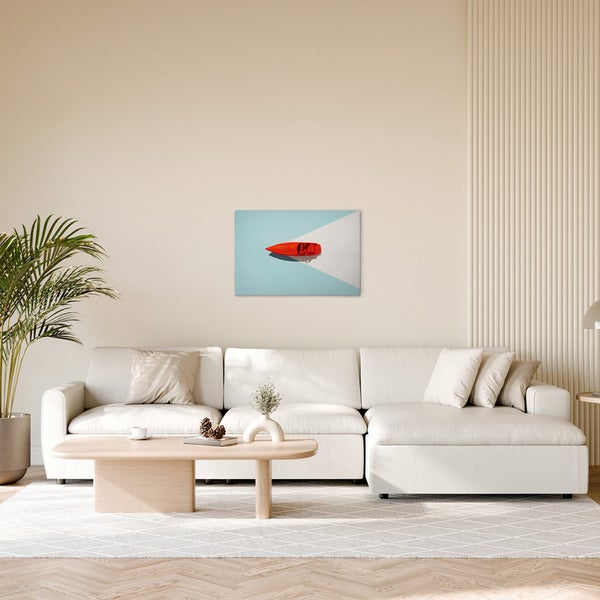 Wohnzimmer mit Sofa und Wandbild eines roten Bootes