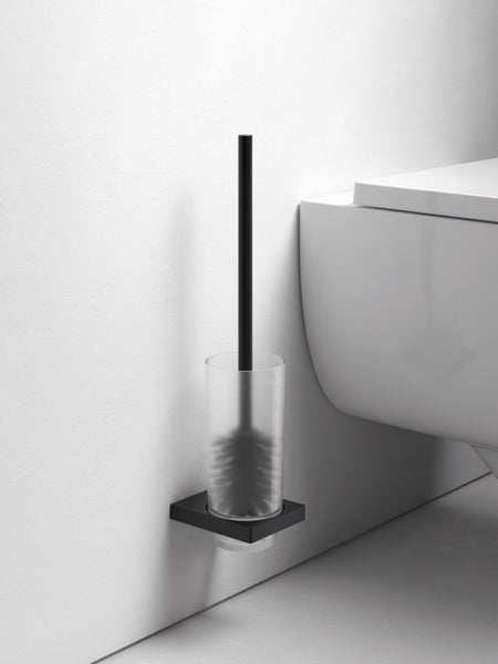 Wandmontierte Keuco Toilettenbürstengarnitur mit mattem Halter und satiniertem Glaseinsatz neben einer wandhängenden Toilette.