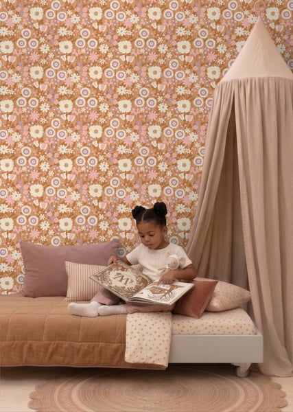 Tapete mit floralem Retro-Muster in einem Kinderzimmer mit einem Kind, das auf einem Bett mit Baldachin ein Buch liest.