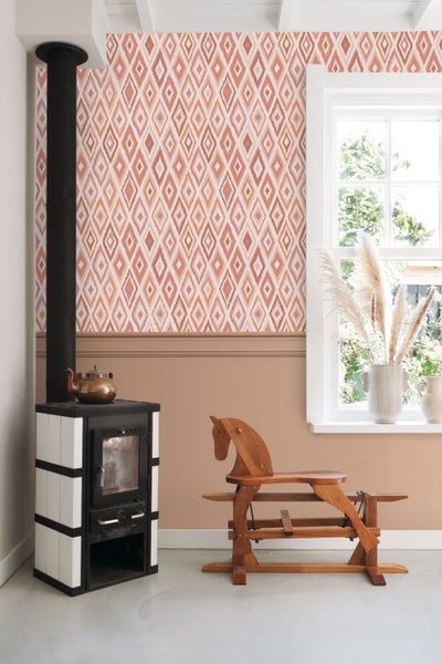 Wohnzimmer mit Kaminofen, Holzpferd und gemusterter Tapete