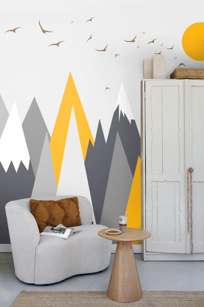 Wohnzimmer mit Sessel, Beistelltisch und Bergmotiv-Wandbild