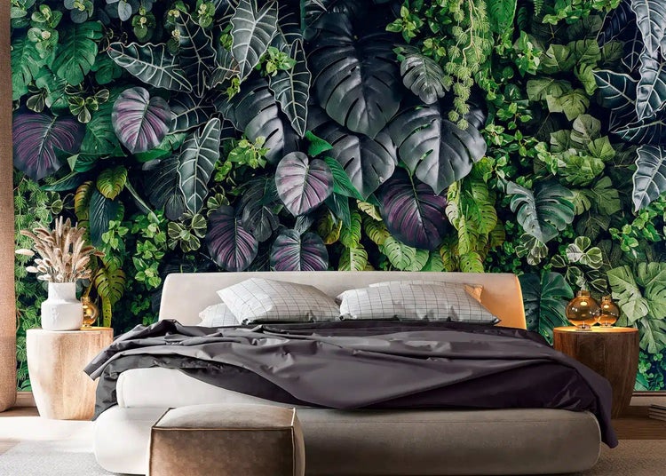 Fototapete mit tropischem Blattmuster aus Monstera und Alocasia in einem modern eingerichteten Schlafzimmer mit dunkler Bettwäsche.