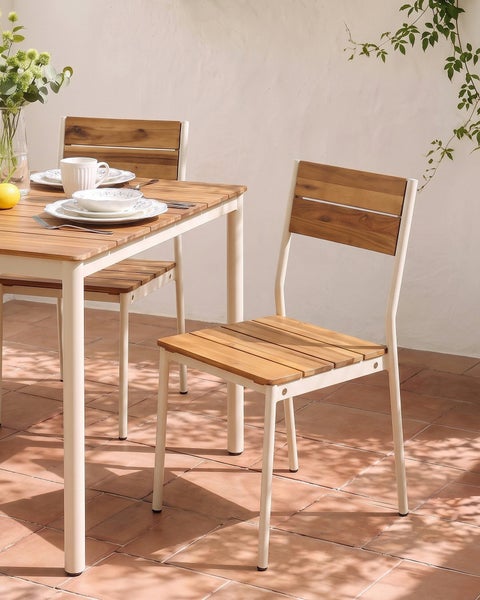 Gartenessgruppe aus Holz und Metall bestehend aus Tisch und Stühlen auf einer Terrasse.
