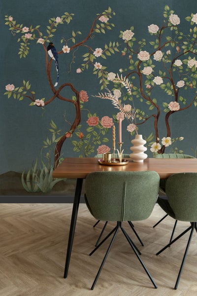 Esszimmer mit Holztisch, grünen Stühlen und einer floralen Tapete mit Vogelmotiven für eine helle und organisierte Atmosphäre.