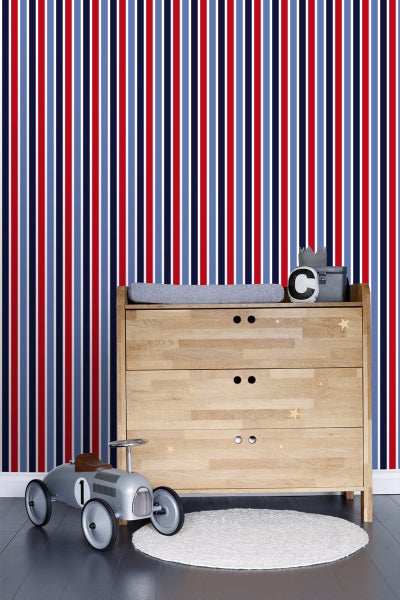 Kinderzimmer mit gestreifter Tapete, Holzkommode und Spielzeugauto