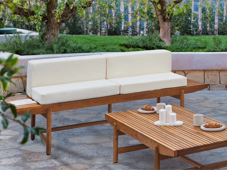 Gartenmöbelset mit Holzbank, Kissen und Holztisch im Außenbereich.
