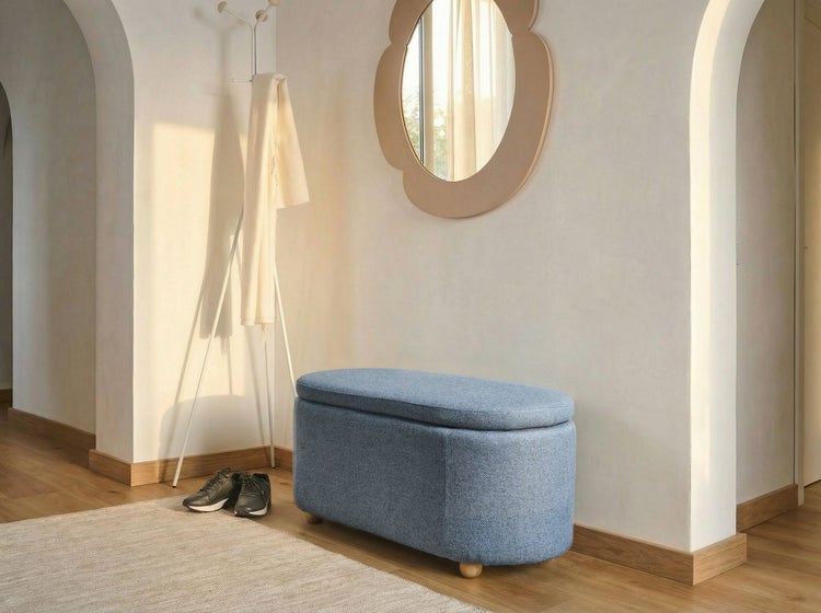 Blaue Polsterbank mit Stauraum in einem hellen, organisierten Flur mit Spiegel und Garderobe.
