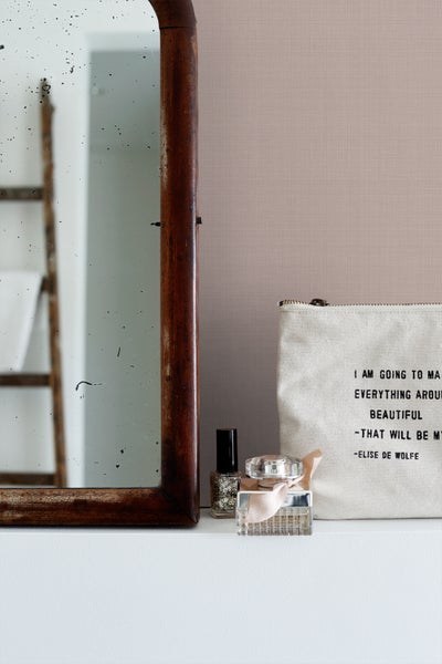 Dekorative Szene mit Spiegel, Nagellack, Parfüm und Kosmetiktasche auf einer Ablage