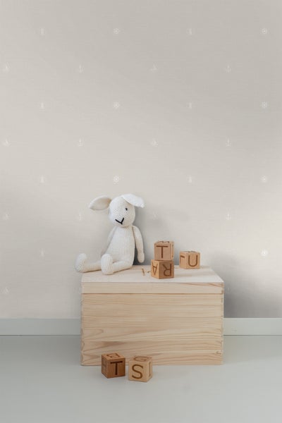 Kinderzimmer mit hellfarbiger Tapete mit Anker-, Leuchtturm- und Steuerradmotiven, Holzkiste und Spielzeug