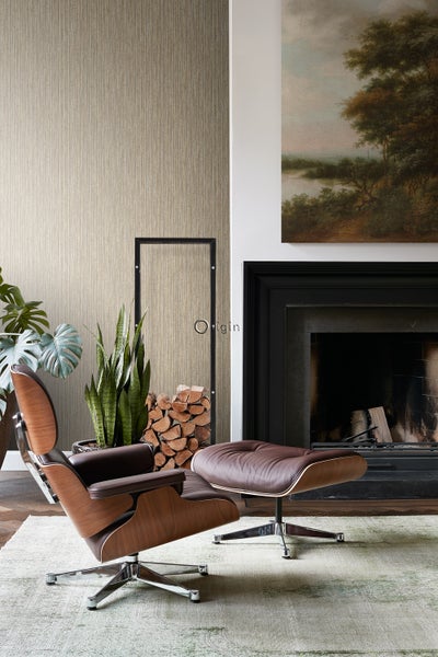 Wohnzimmer mit Sessel, Fußhocker, Kamin und gemusterter Tapete