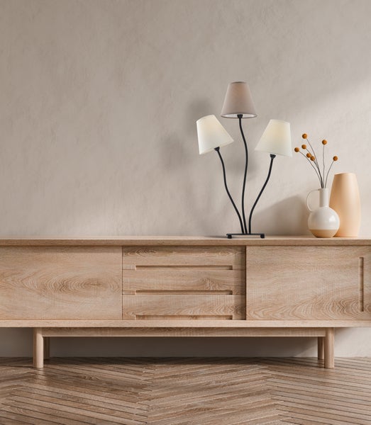 Kommode mit Schubladen, Tischleuchte und Dekorationsvasen auf einem Holzboden