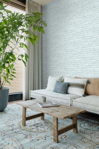 Wohnzimmer mit Sofa, Couchtisch und gemusterter Tapete