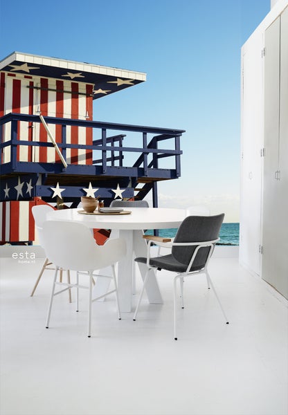 Szene mit rundem Tisch und Stühlen vor einer Fototapete mit einem amerikanischen Rettungsschwimmer-Turm