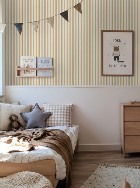 Gemütliches Kinderzimmer mit vertikal gestreifter Tapete in Pastellfarben, einem Holzbett und einer passenden Kommode aus hellem Holz.