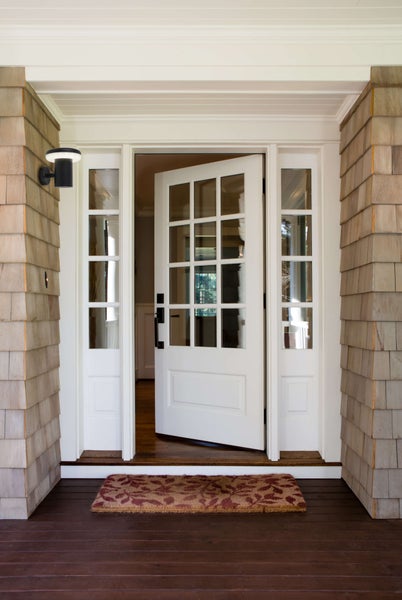Eingangsbereich mit Haustür, Seitenteilen, Außenleuchte und Fußmatte.