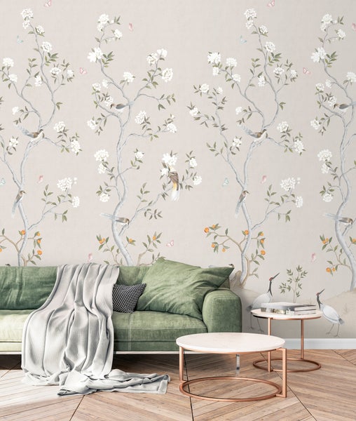 Wohnzimmer mit gemusterter Tapete, grünem Sofa und Beistelltischen