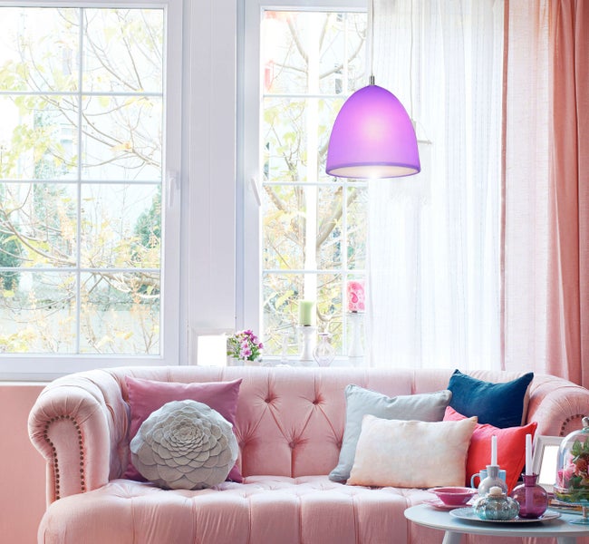 Wohnzimmer mit Sofa, Kissen, Tisch und Pendelleuchte