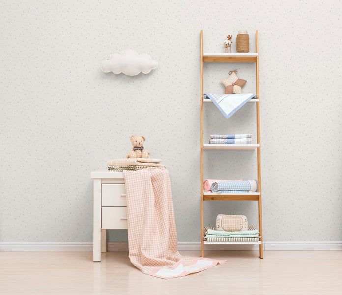 Helles Kinderzimmer mit Kommode, Holzregal und Dekorationsgegenständen.