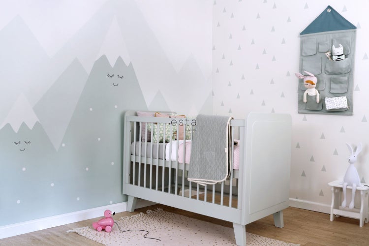 Babyzimmer mit Kinderbett, Wandbild mit Bergmotiven und Spielzeug