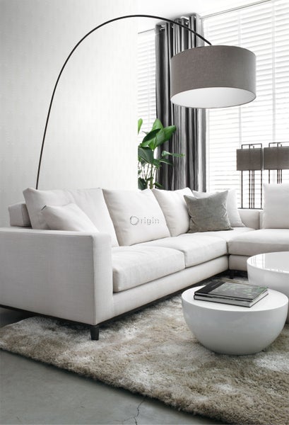 Wohnzimmer mit Ecksofa, Stehlampe und Couchtischen