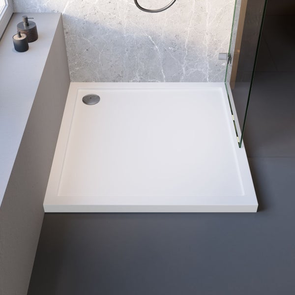 Quadratische Duschwanne aus Acryl mit Ablaufgarnitur in einem Badezimmer.