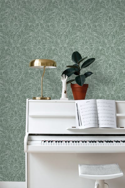 Szene mit gemusterter Tapete, weißem Klavier, Lampe und Zimmerpflanze