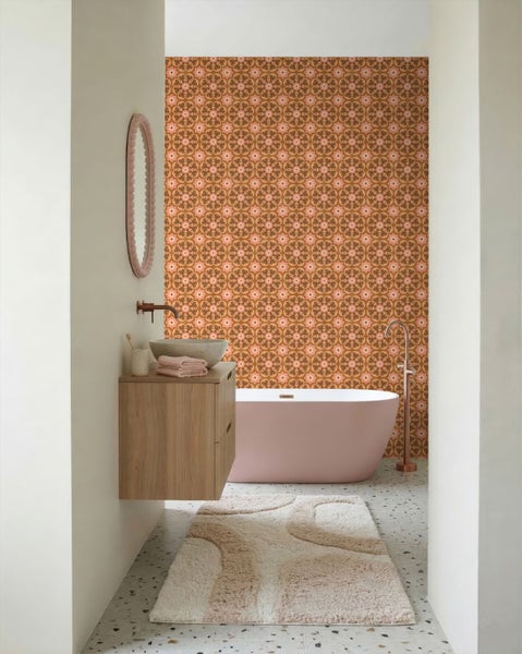 Modernes Badezimmer mit gemusterter Tapete im Retro-Stil, freistehender Badewanne, Holz-Waschtischunterschrank und weichem Badeteppich.