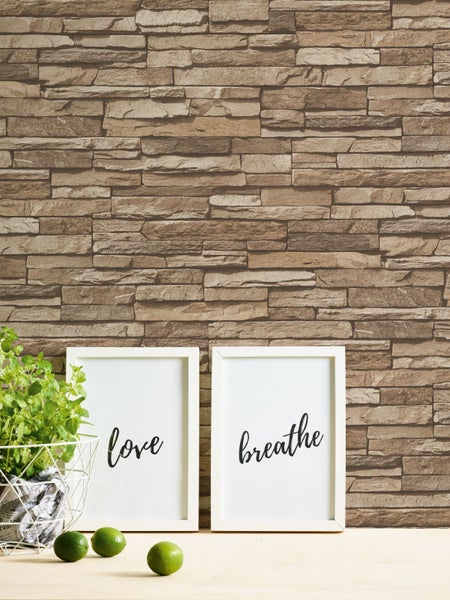 Wandgestaltung mit Steinoptik-Tapete, Pflanze und Dekoration auf Tisch