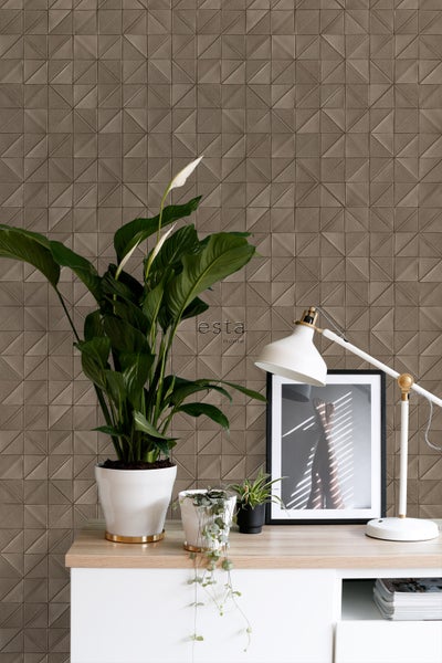 Dekorative Tapete mit geometrischem Muster und Zimmerpflanzen auf einem Schreibtisch