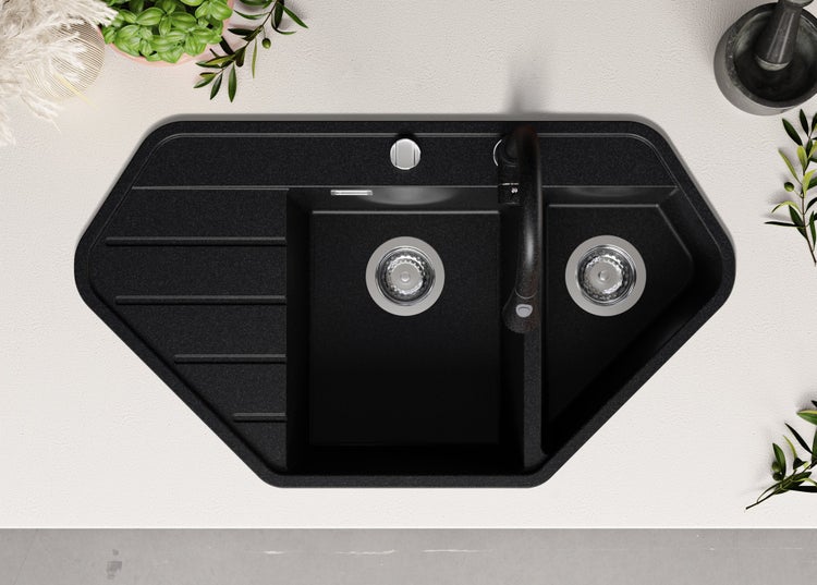 Schwarze Eckspüle mit Abtropffläche und Armatur auf einer Arbeitsplatte