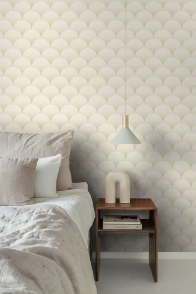 Schlafzimmer mit Bett, Nachttisch, Lampe und Tapete mit Halbkreis Muster