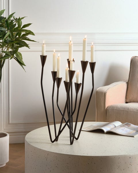 Kerzenständer aus Metall mit neun Kerzen auf einem Tisch