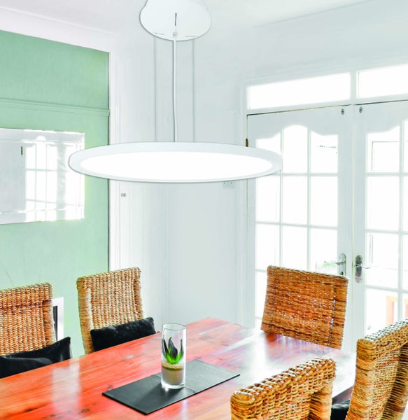 Esstisch mit Korbstühlen unter einer runden Hängeleuchte