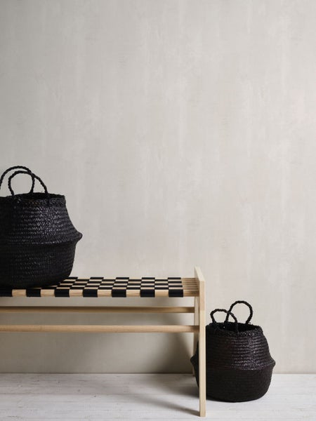 Bank mit Schachbrettmuster und zwei schwarzen Aufbewahrungskörben