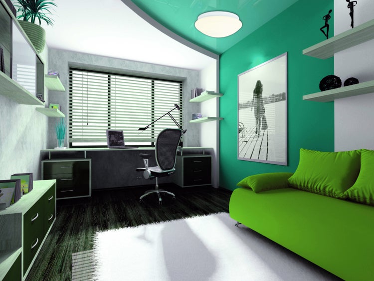 Helles Arbeitszimmer mit Schreibtisch, Bürostuhl, Regalen und Sofa