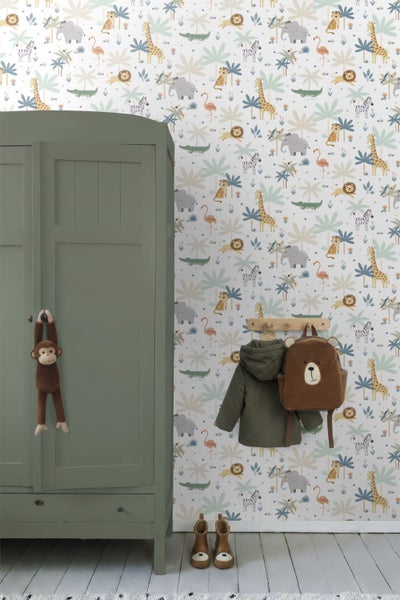 Kindertapete mit Dschungeltieren und Palmen in einem hellen Kinderzimmer mit grünem Kleiderschrank und Holzgarderobe.
